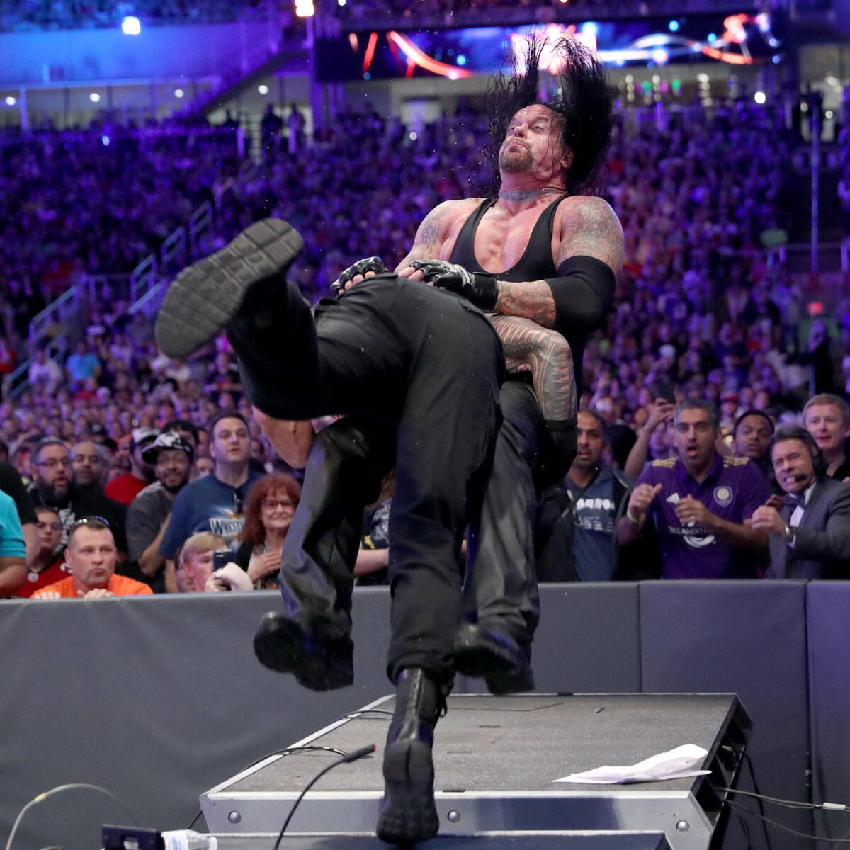 Undertaker menerima rempuhan bahu daripada Roman Reigns