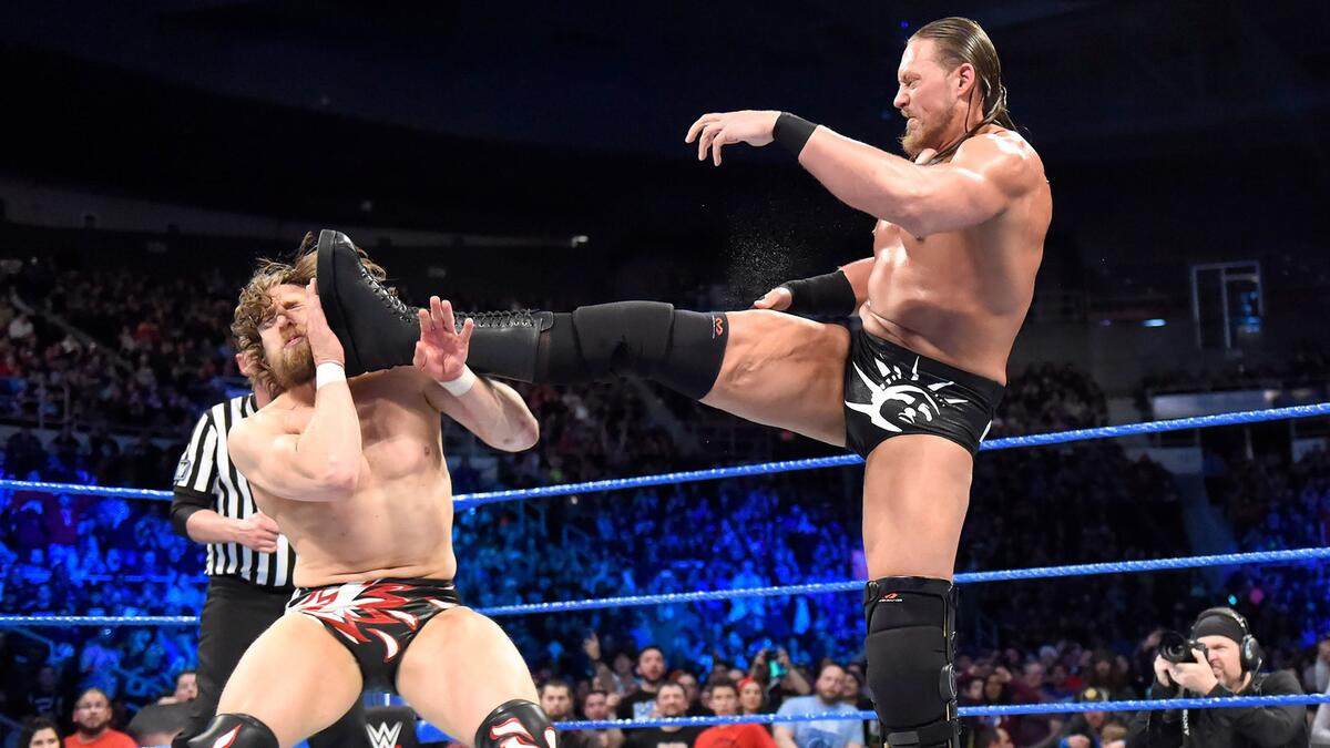 Big Cass strikes next, launching a sneak attack on Bryan and laying him out with a devastating big boot!