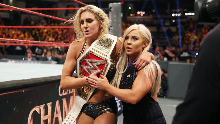 Dana helps the retaining Raw Women's Champion leave ringside.