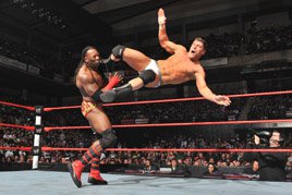 Cody Rhodes levels Booker T with a springboard kick.