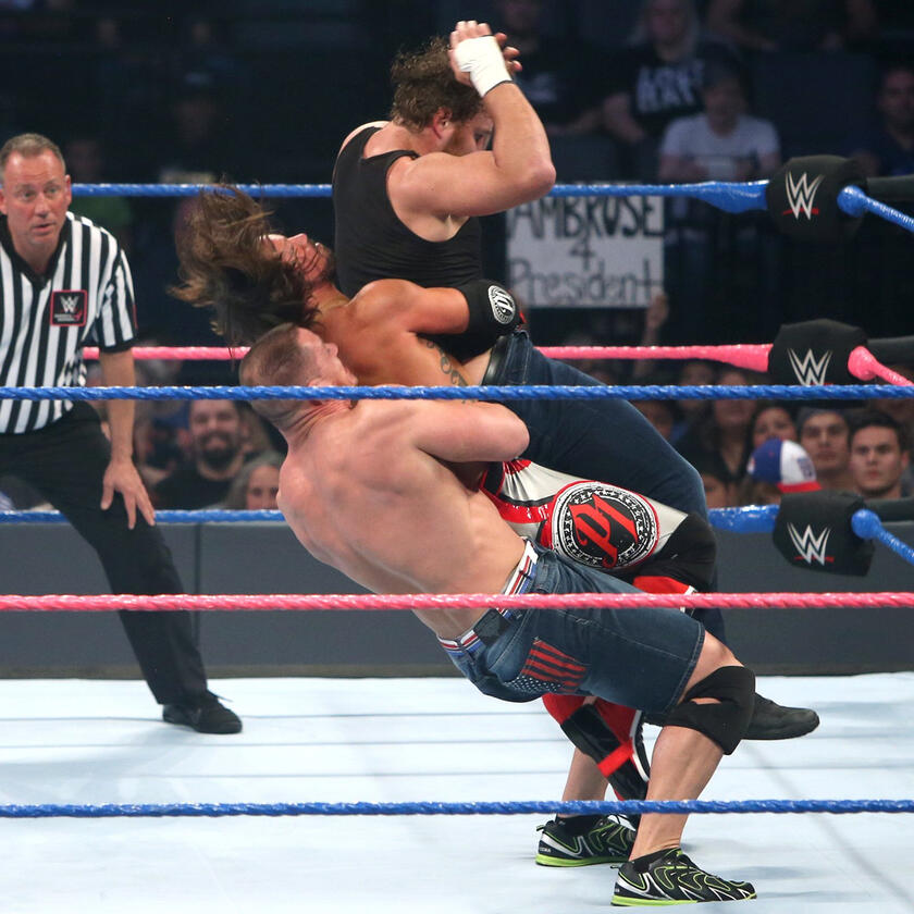 The Cenation Leader shows his incredible strength by hurling both his opponents with a German suplex.