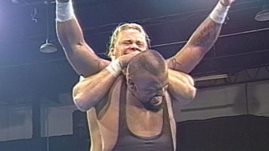 Shane Douglas applied a Full Nelson onto Taz as Taz winces in pain at Wrestlepalooza 1997.