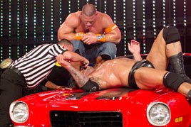 John Cena watches as the referee asks Batista if he quits